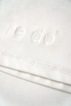 Closeup af logoet på re do® Active T-shirt i Star White. #star white