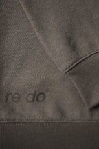 Closeup af ribkant, logo og ærme på re do® Crewneck sweatshirt i Ash Brown