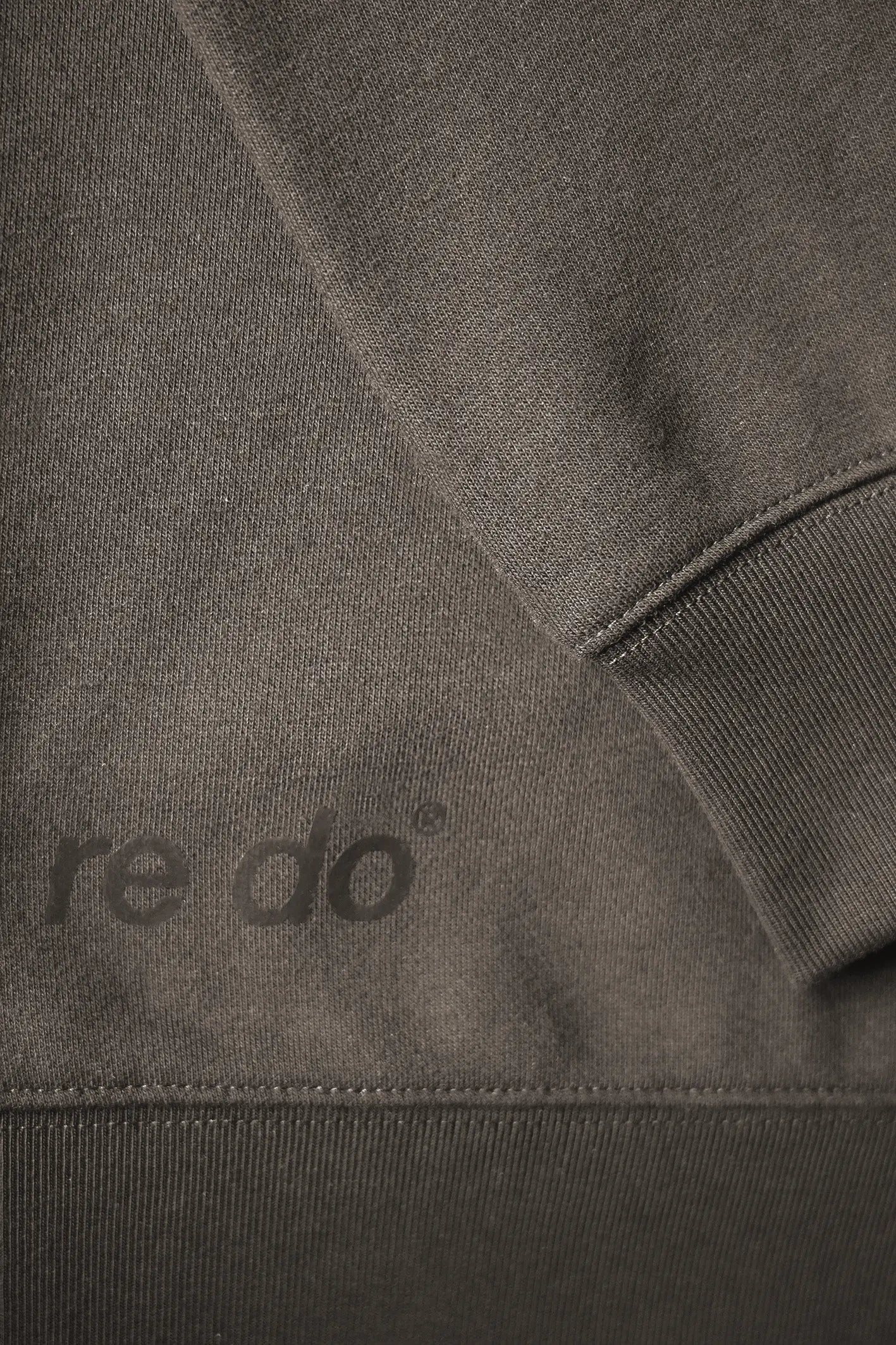 Closeup af ribkant, logo og ærme på re do® Crewneck sweatshirt i Ash Brown