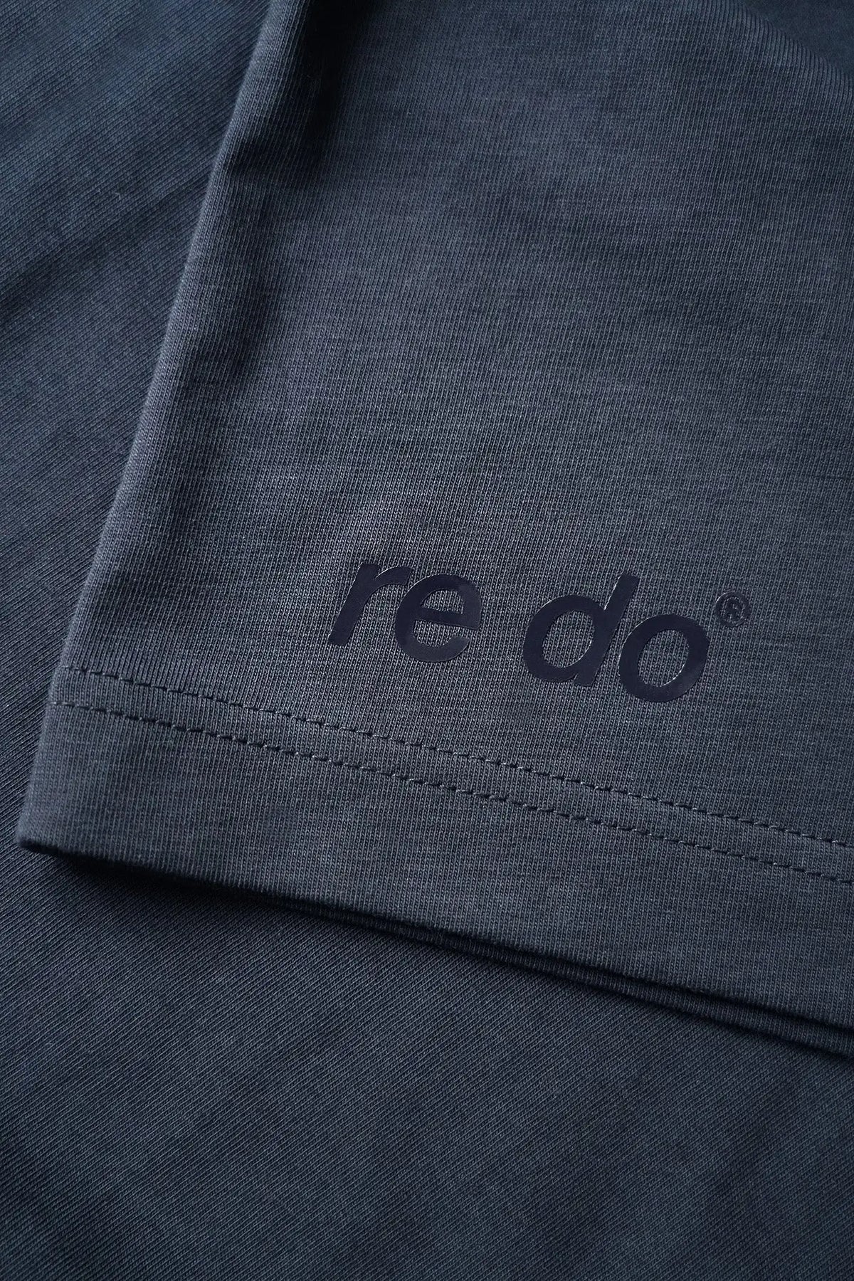 Closeup af logo og syninger på re do® Bomuld T-shirt i #Navy Blue