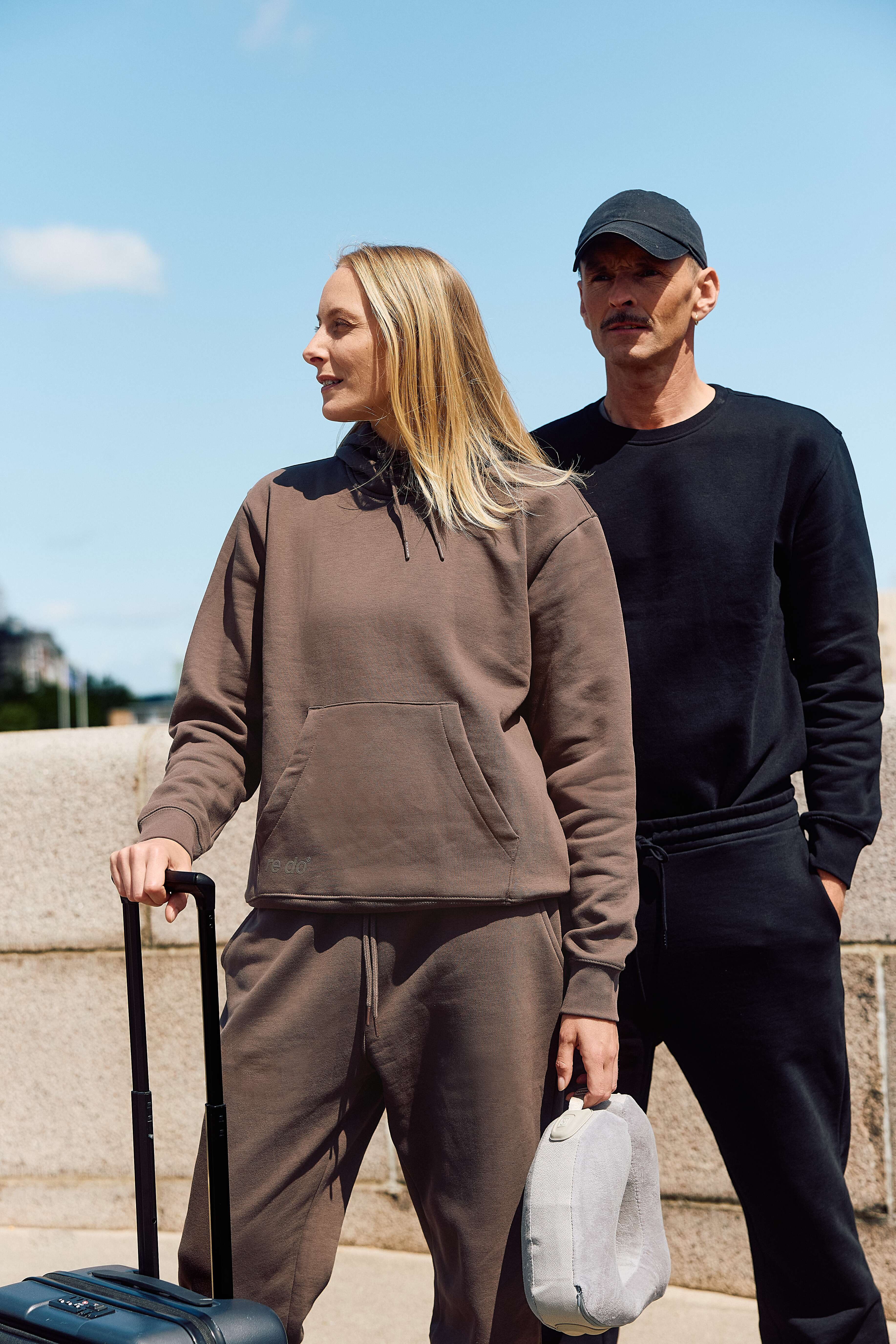 Kvinde iført Ash Brown hoodie og sweatpants fra re do®, og mand iført navyblå crewneck sweatshirt og sweatpants fra re do® 
