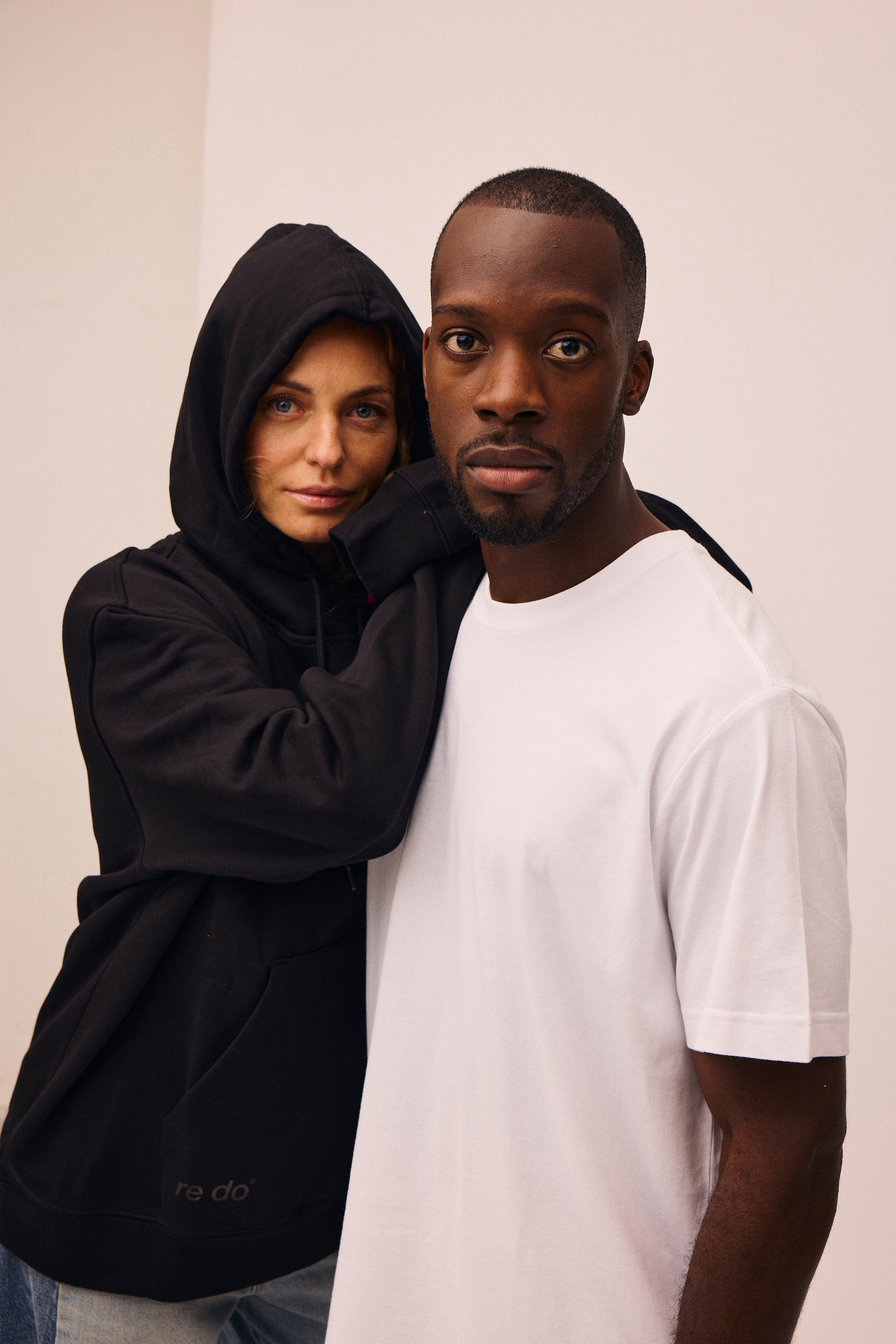 Kvinde iført sort hoodie fra re do® og mand iført hvid bomulds t-shirt fra re do® 