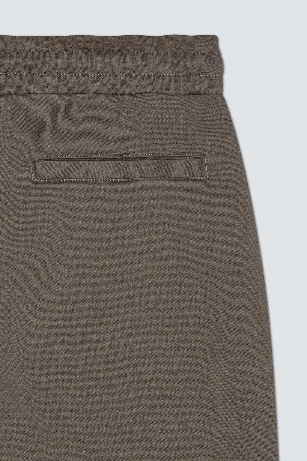 Closeup af elastikkant og baglomme på re do® sweatpants i Ash Brown