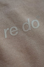Closeup af logo på re do® sweatpants i Ash Brown