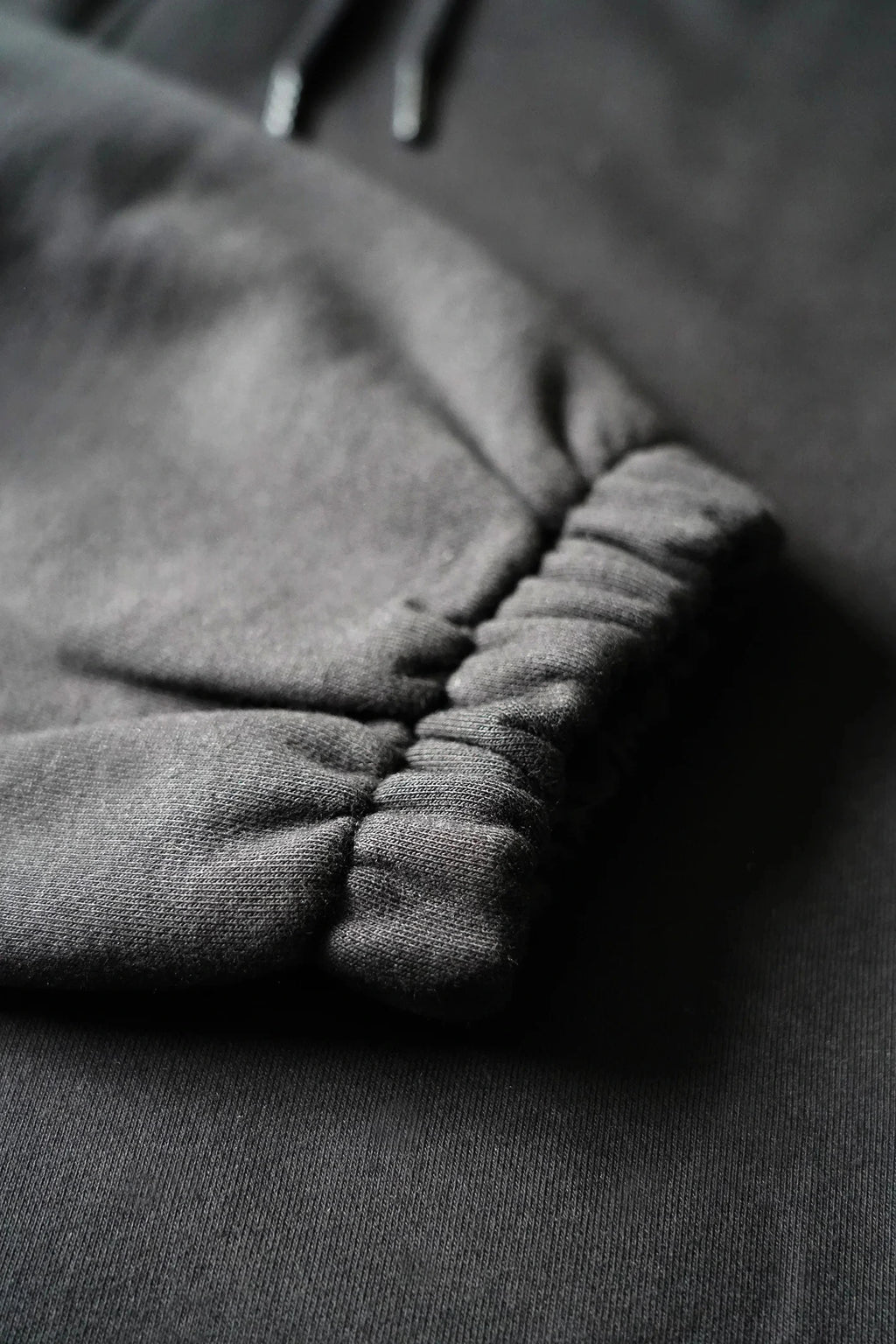 Closeup af bukseben på re do® sweatpants i sort