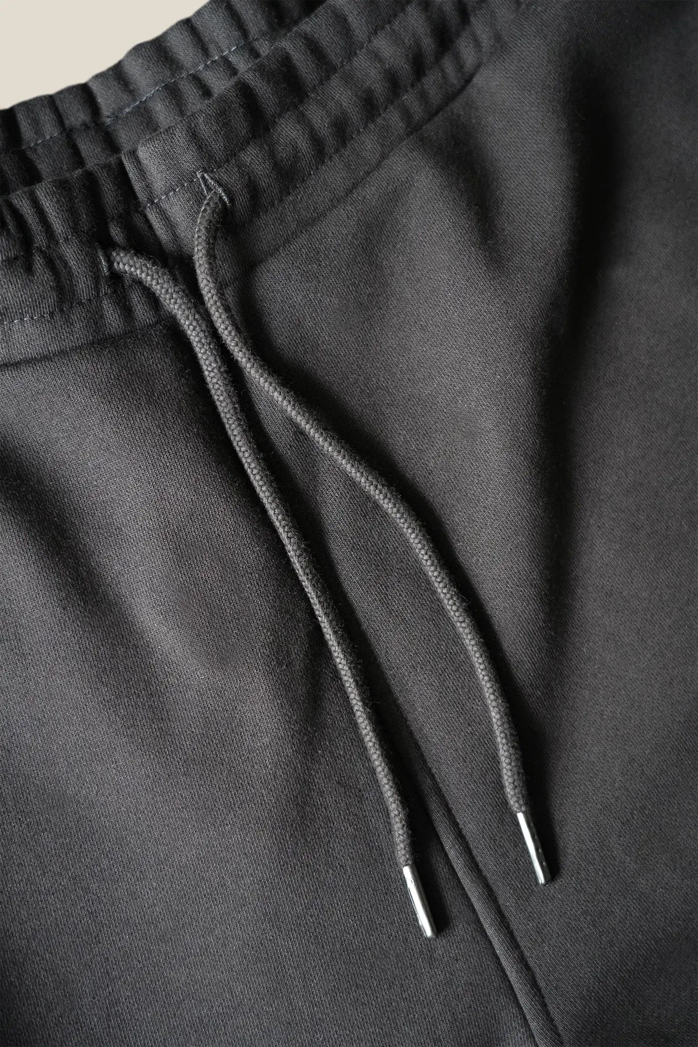 Closeup af elastikkant og bindesnore på re do® sweatpants i sort