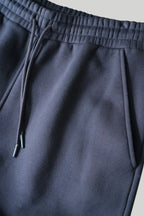 Closeup af elastikkant, bindesnore og sidelomme på re do® sweatpants i #Navy Blue
