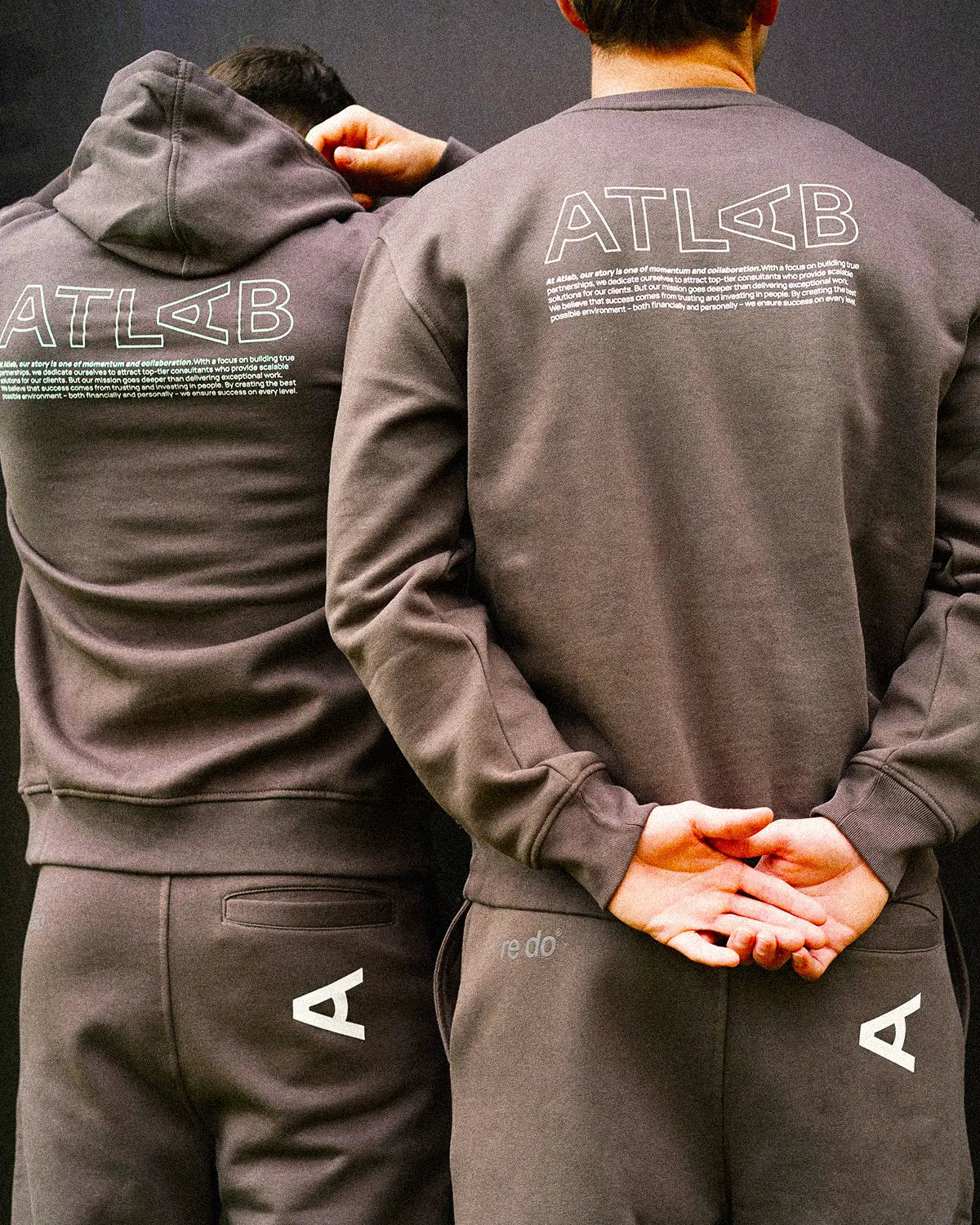 To mænd iført firmatøj fra re do® i Ash Brown med logo tryk