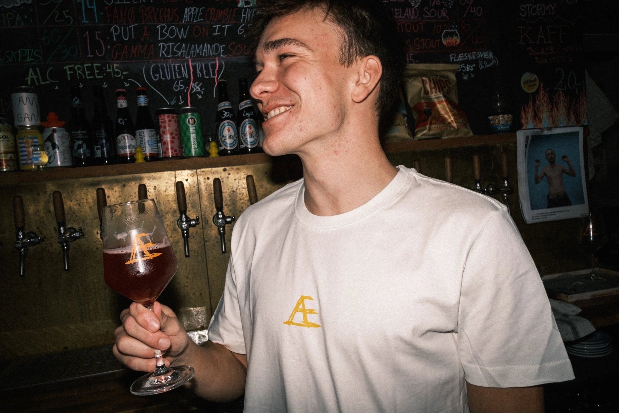 Medarbejder iført T-shirt med tryk fra re do® i Star White, model Frej i bomuld, i collab med Café Mundhæld bag baren.