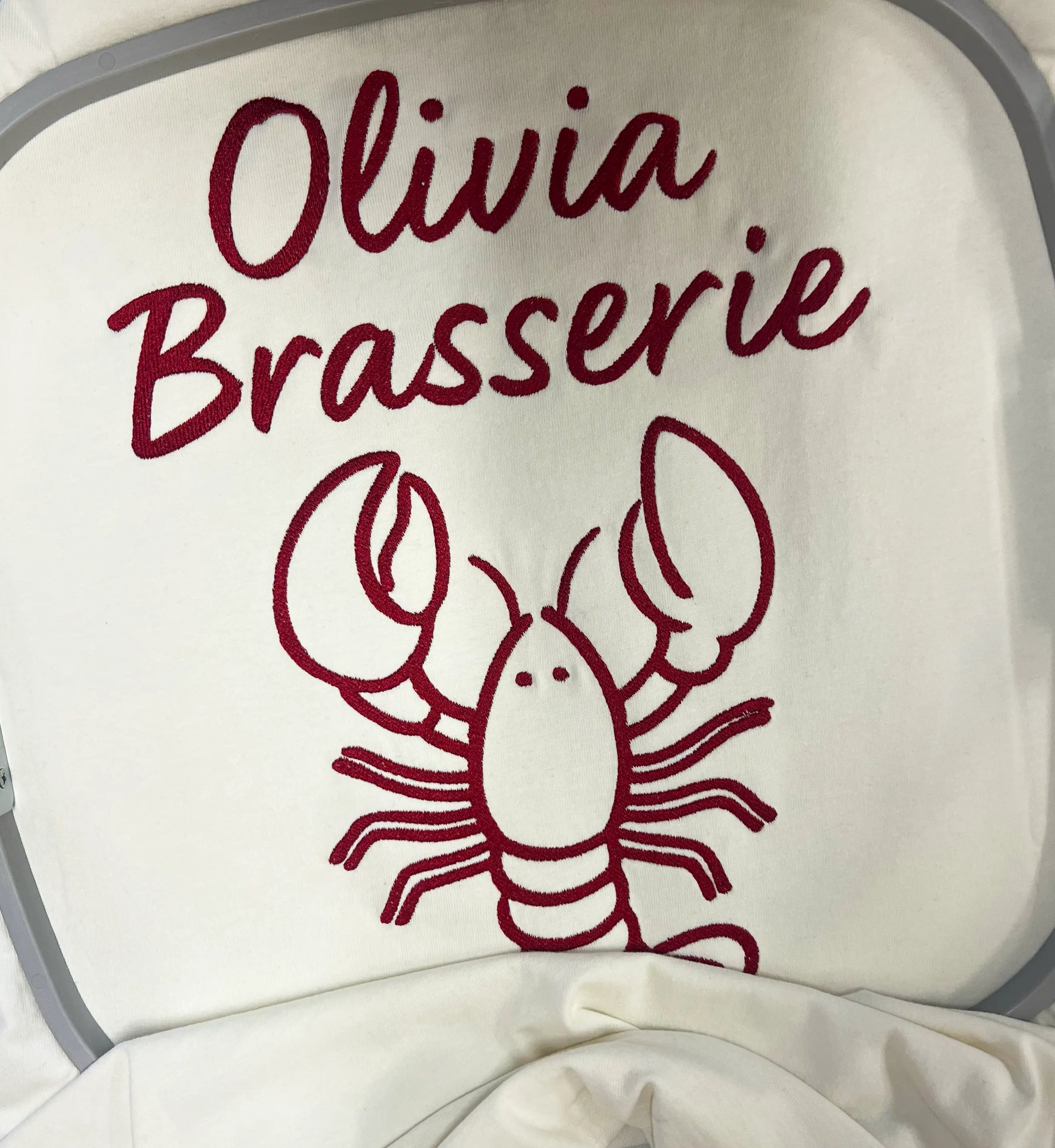 Bomuld T-shirt i Star White fra re do® med broderi fra BrandLabs, collab med Olivia Brasserie. Firmatøj med logo. 