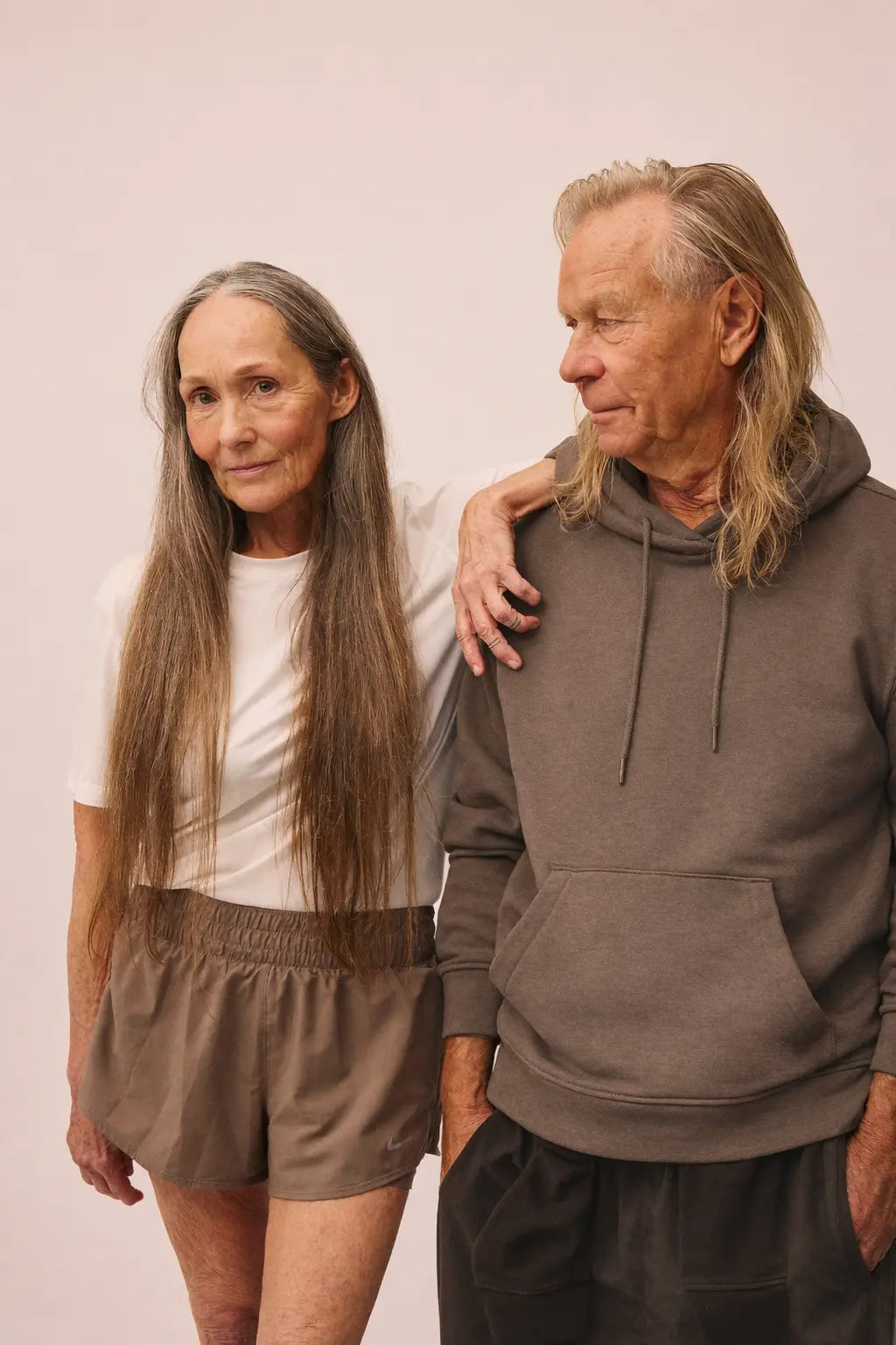 Kvinde iført Movement t-shirt i hvid fra re do® og mand iført hoodie i Ash Bown fra re do®