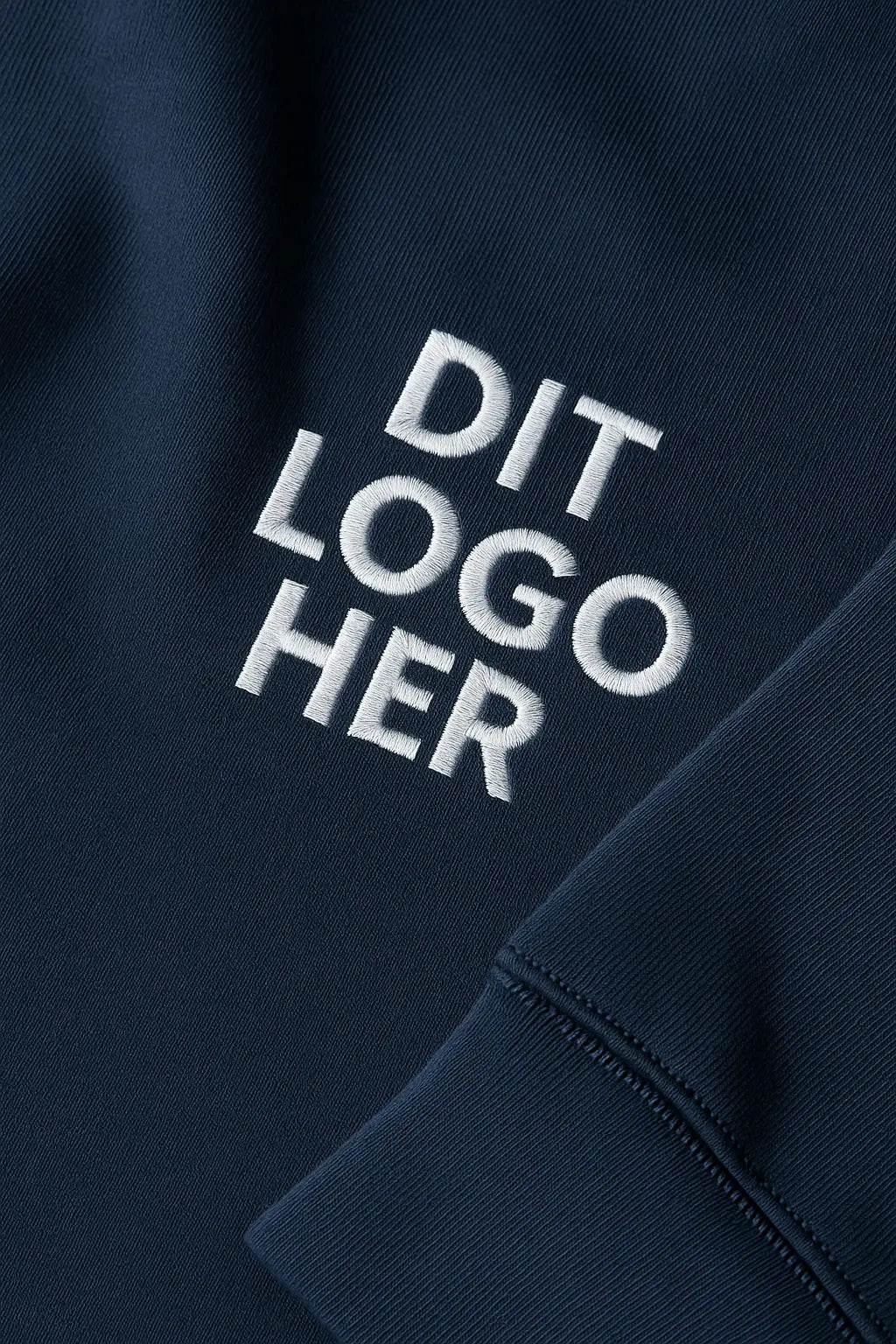 re do® tøj med logo, firmatøj med brodering af logo. re dos broderiproces – logotekst broderet med synlig hvid trådstruktur på blå sweatshirt. 