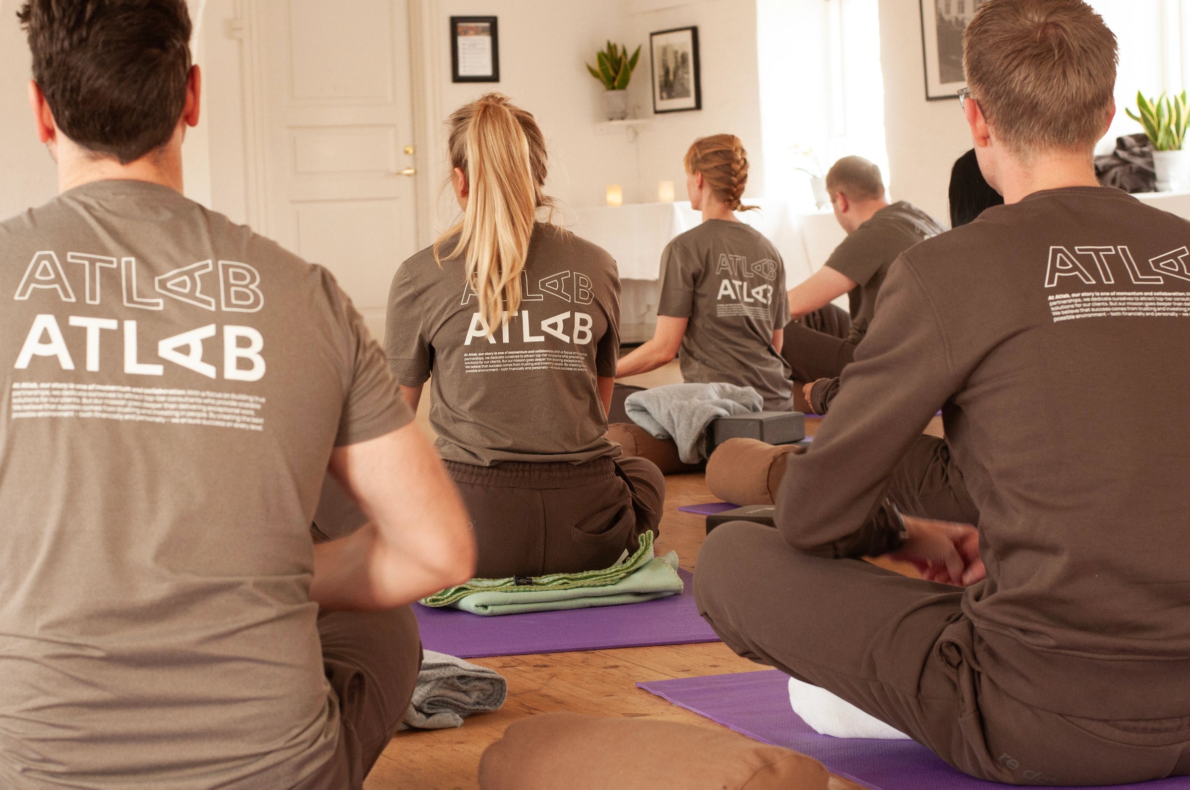 re do x Atlab collab. Hold sidder i meditation iført matchende firmatøj med tryk fra re do® og tøj med logo fra re do®.